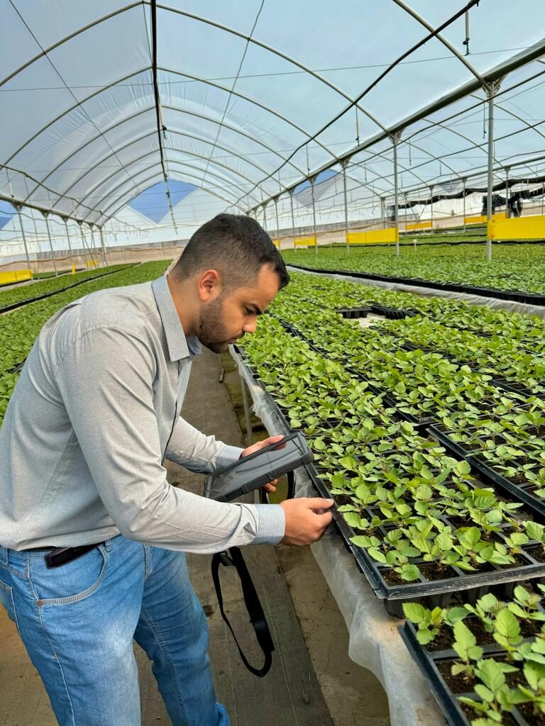 Rafael Nobre registrando dados da operação no tablet, dentro do viveiro
